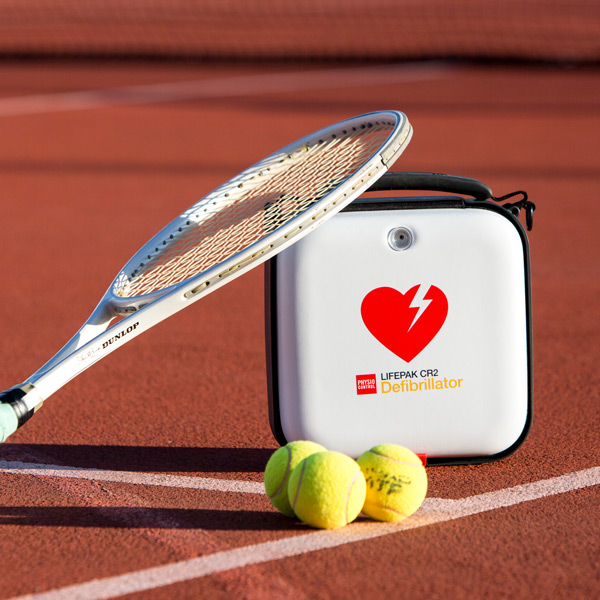 Ett tennisrack stående på en hjärtstartare på en idrottsanläggning. 