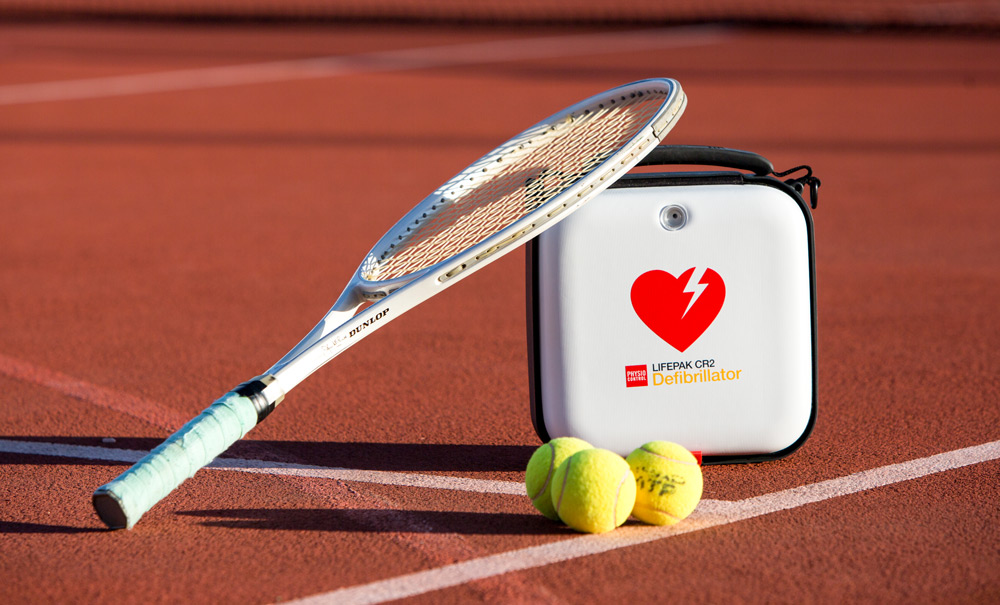 Ett tennisrack stående på en hjärtstartare på en idrottsanläggning. 