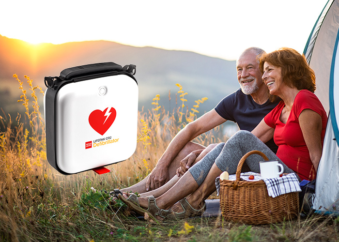 Hjärtstartare som visas tillsammans med ett äldre par som har picknick vid sitt tält på sin semester. 