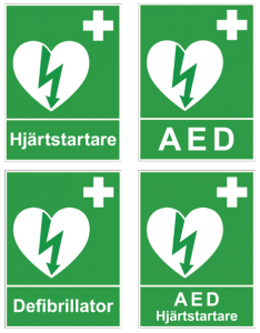 Fyra gröna skyltar med symbol för hjärtstartare och texterna: hjärtstartare, AED, defibrillator och AED hjärtstartare.